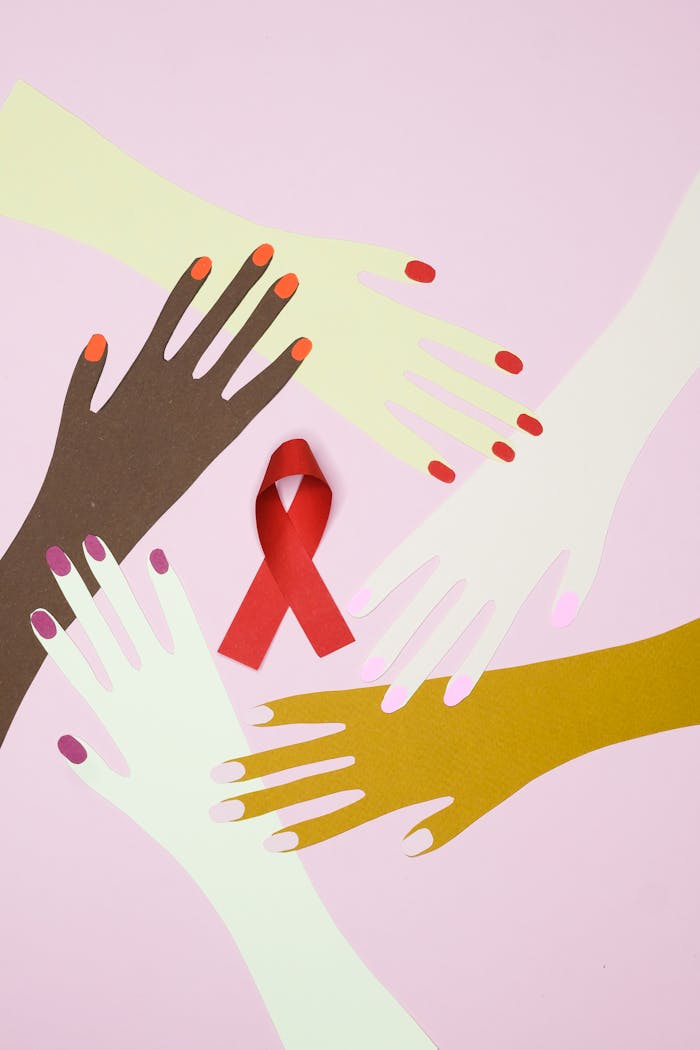 Illustration of diverse hands surrounding a red awareness ribbon symbolizing unity and health awareness.